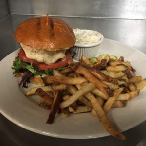 A white plate with a burger and fries on it.