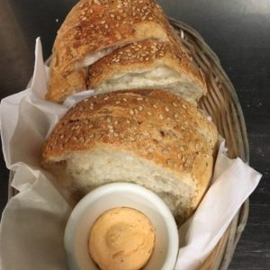 A basket with bread and dip in it.