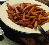 A plate of sweet potato fries on a table.