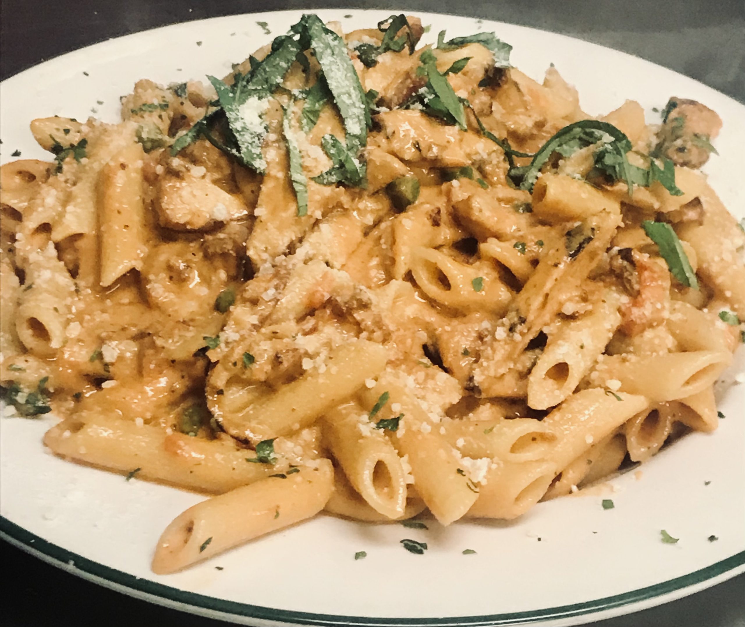A plate of pasta with chicken and sage.