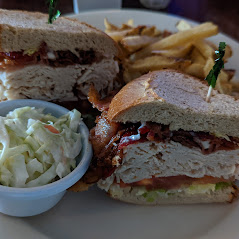 A sandwich with fries and coleslaw on a plate.