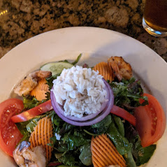 A plate of shrimp salad with rice and vegetables.