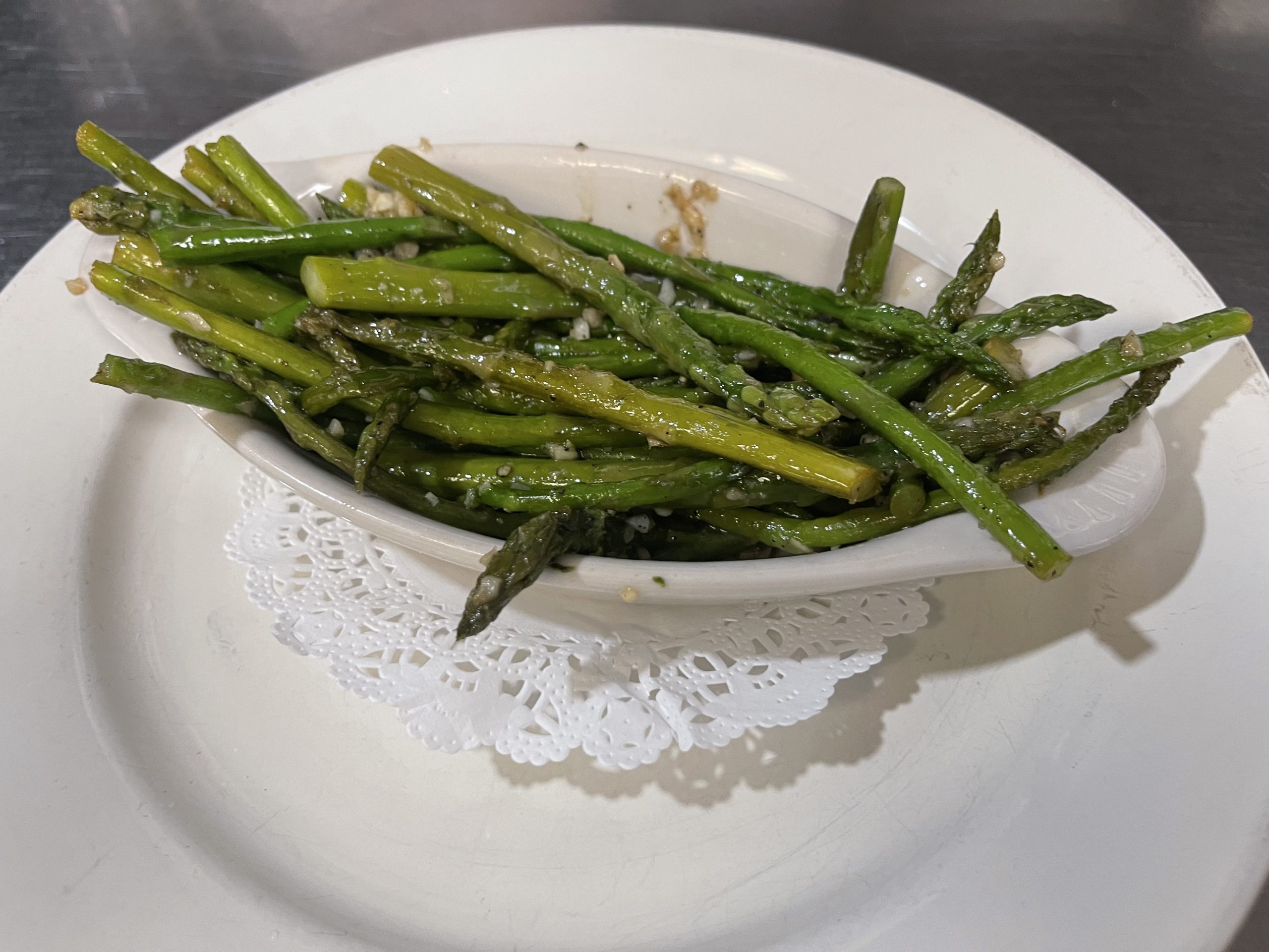 Asparagus on a white plate with a doily.